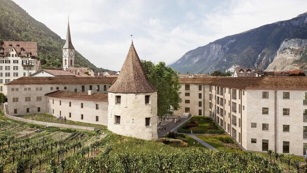 A historic building with a tower, a church, and a mountain backdrop. - Bogentrakt - Hostel (Chur)