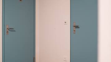 A hallway with two blue doors, one labeled "WC" and the other with a door handle.