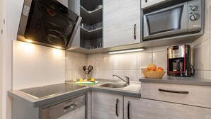 Eine moderne Küche mit Einbauofen, Mikrowelle und Kaffeemaschine.