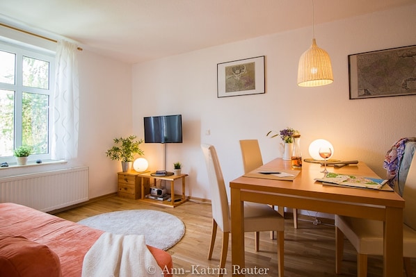 Relax in a spacious living area with a sofa, dining table, and flat-screen TV.