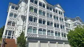 Un edifici de diverses plantes amb una façana simètrica, grans finestres i una entrada central.