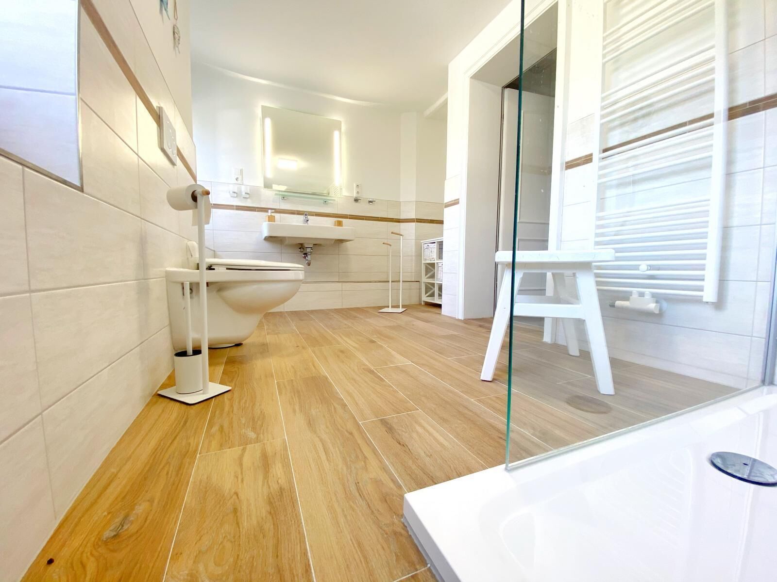 Een moderne badkamer met toilet, wastafel en douchecabine van glas.