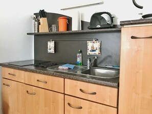 Een koelkast, een oven, een kookplaat, een koffiezetapparaat/waterkoker