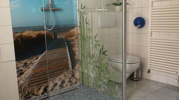 Ein Badezimmer mit Duschkabine, Toilette und Heizkörper.