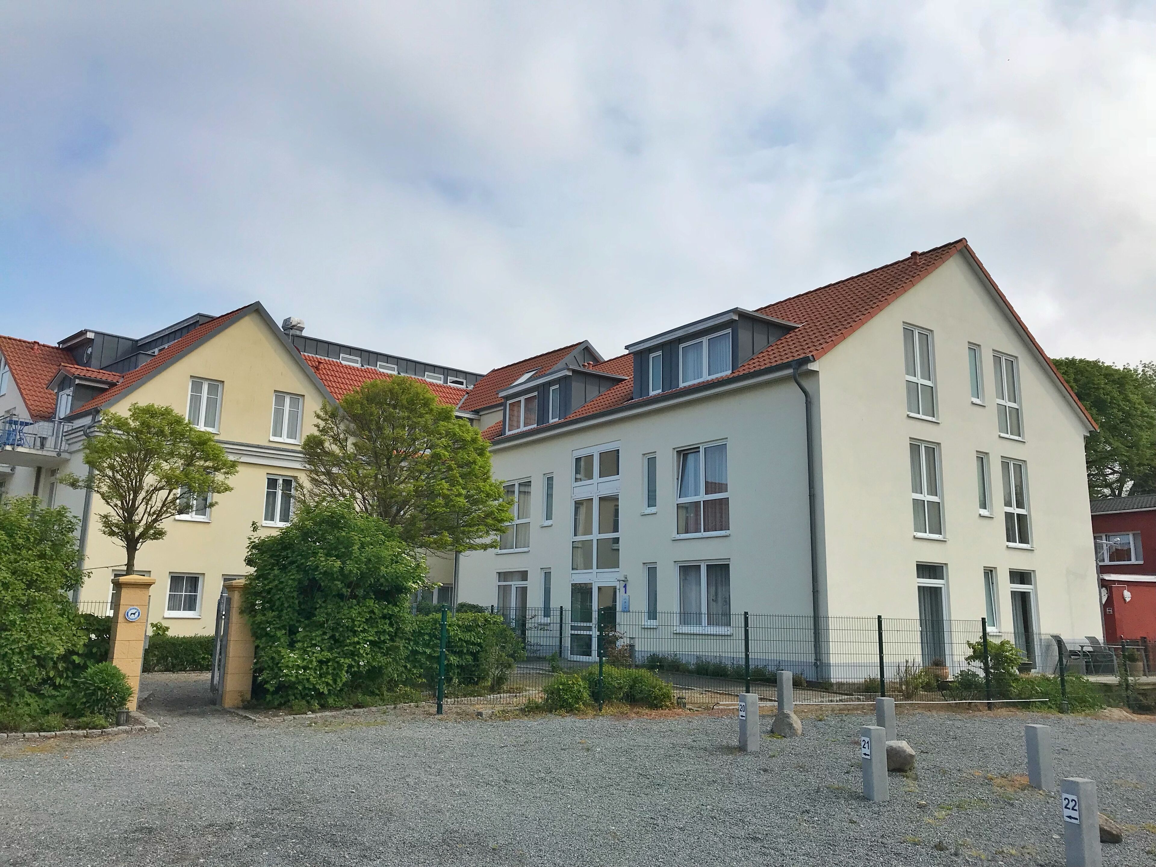 Eine Reihe moderner Apartmentgebäude mit roten Ziegeldächern und zahlreichen Fenstern.