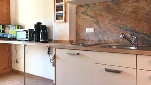 A modern kitchen with a granite countertop, stainless steel sink, and white cabinetry. - Hochzeitsberg - Double room / Apartment "Tromsö" in Breege (Breege)