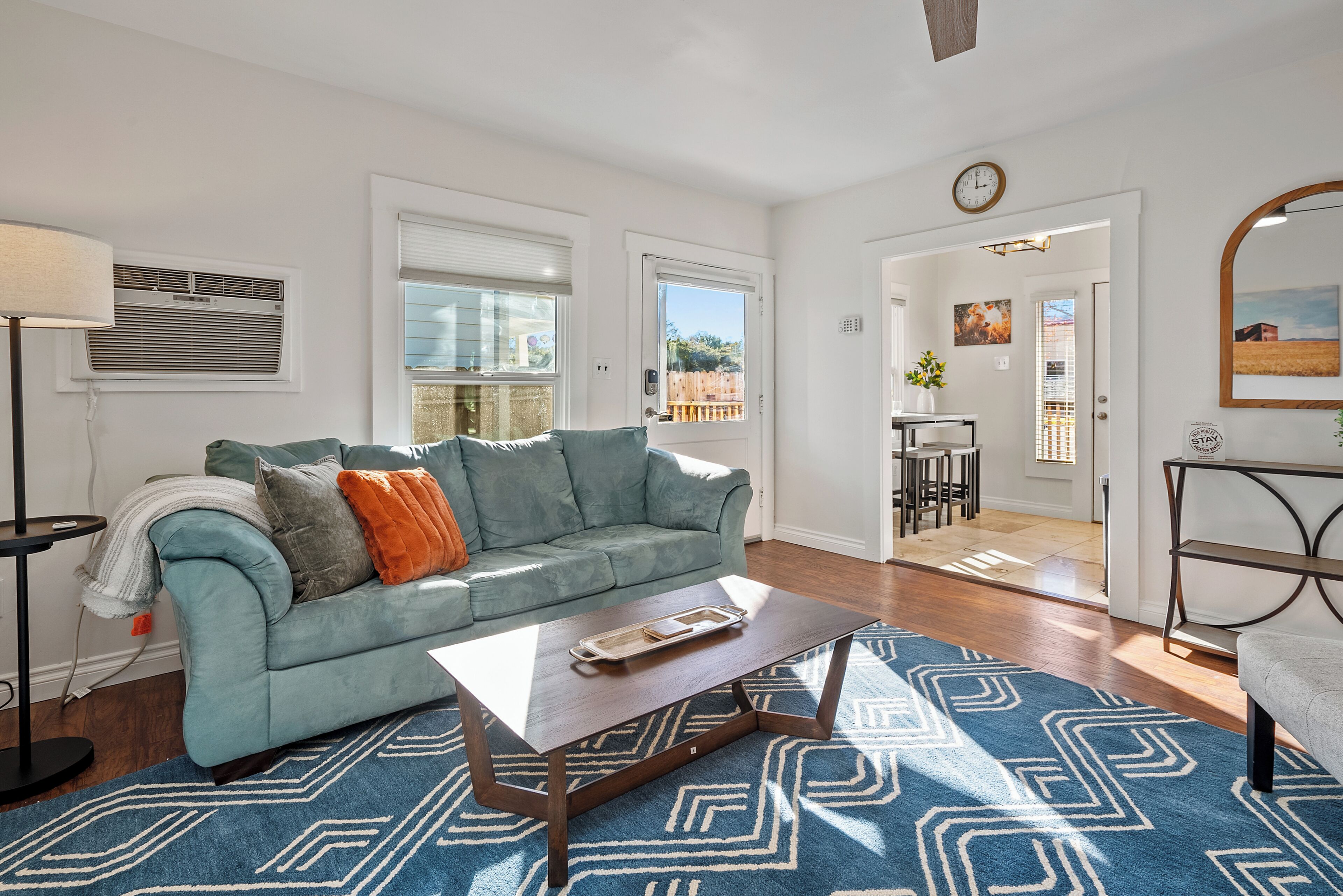 A living room with a sofa, coffee table, and a patterned rug.