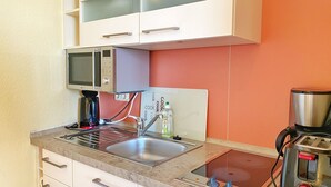 A compact kitchen with a microwave, toaster, and coffee maker. - Apartment 309 - Roundel at the Jasmundtherme (Neddesitz)