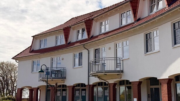 A multi-story building with a red-tiled roof, multiple balconies, and large glass doors. - Apartment 309 - Roundel at the Jasmundtherme (Neddesitz)