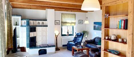 A cozy living room with a fireplace, leather furniture, and wooden shelves.