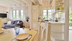A cozy room with a sofa, dining table, and kitchen area. - Landhaus Vilmnitz, Wohnung 7 (Vilmnitz)