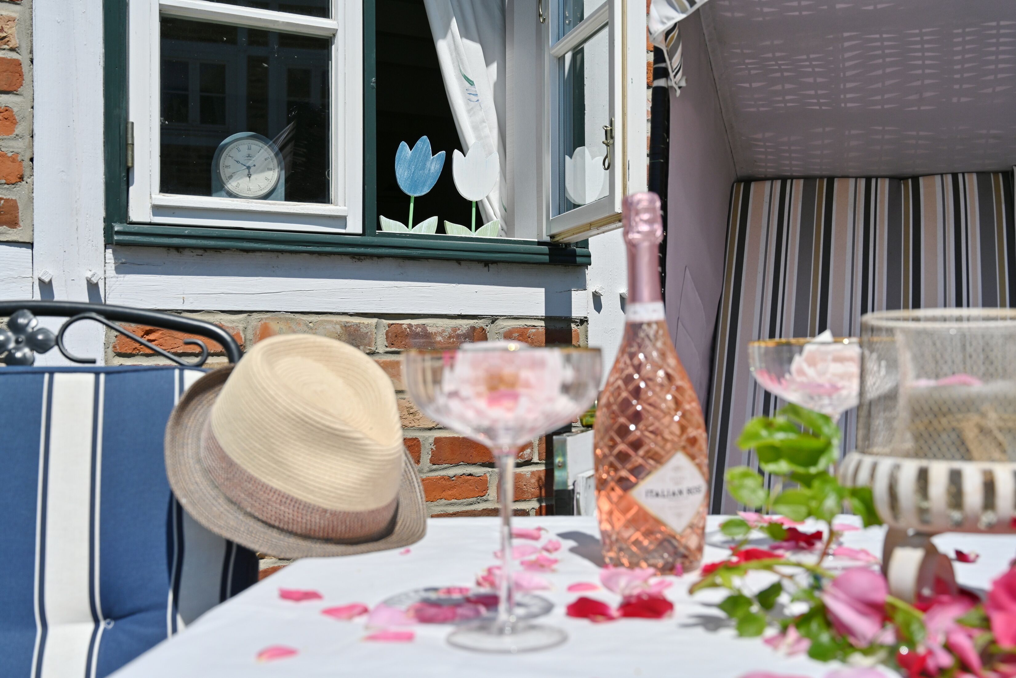 A table with a bottle, a glass, and a hat.