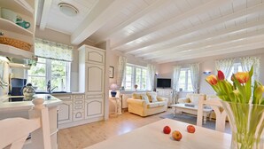 A bright, white interior with a kitchen, dining area, and living room. - Landhaus Vilmnitz, Wohnung 8 (Vilmnitz)