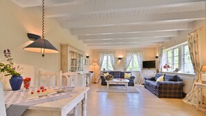 A spacious living area with a dining table, two sofas, and a TV. - Country house Vilmnitz, apartment 9 (Vilmnitz)