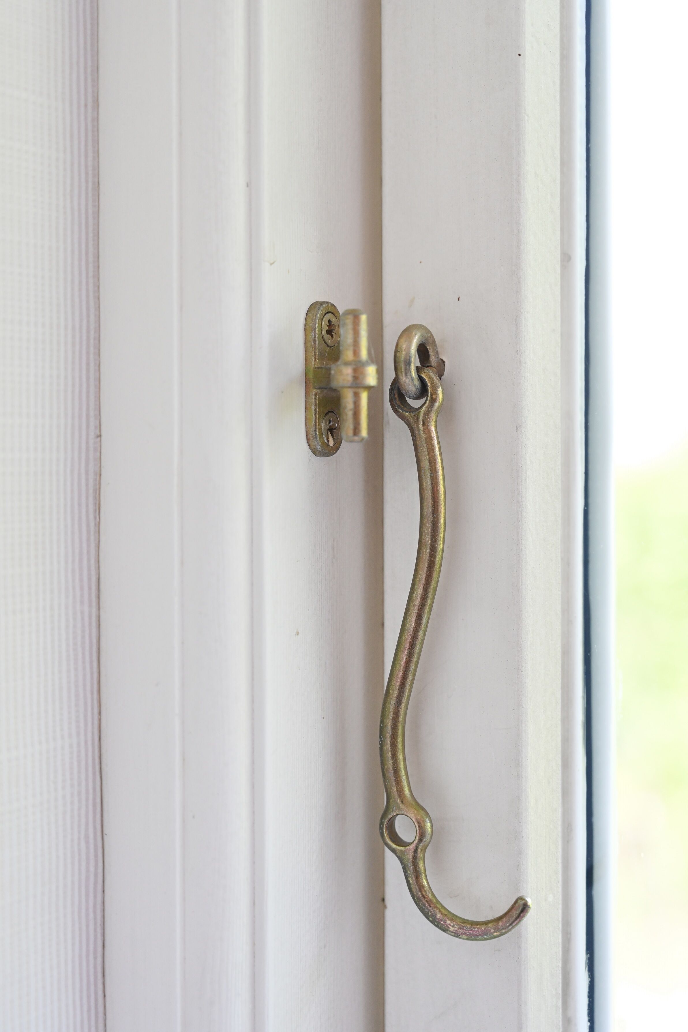 A white door with a brass door handle and a lock.
