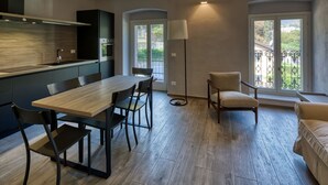Eine moderne Küche mit Essbereich, einer Stehlampe und Blick ins Freie.