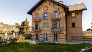 Ein mehrgeschossiges Gebäude mit Balkonen, einem Rundfenster und einem geneigten Dach.
