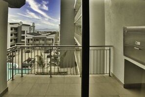 A balcony with a view of a swimming pool and buildings in the background. - Nivica Lifestyle Living 57, Langebaan 4-Sleeper (Langebaan)