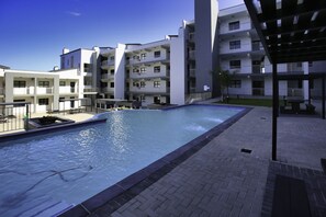 A modern hotel with a swimming pool, multiple balconies, and a covered outdoor area. - Nivica Lifestyle Living 57, Langebaan 4-Sleeper (Langebaan)