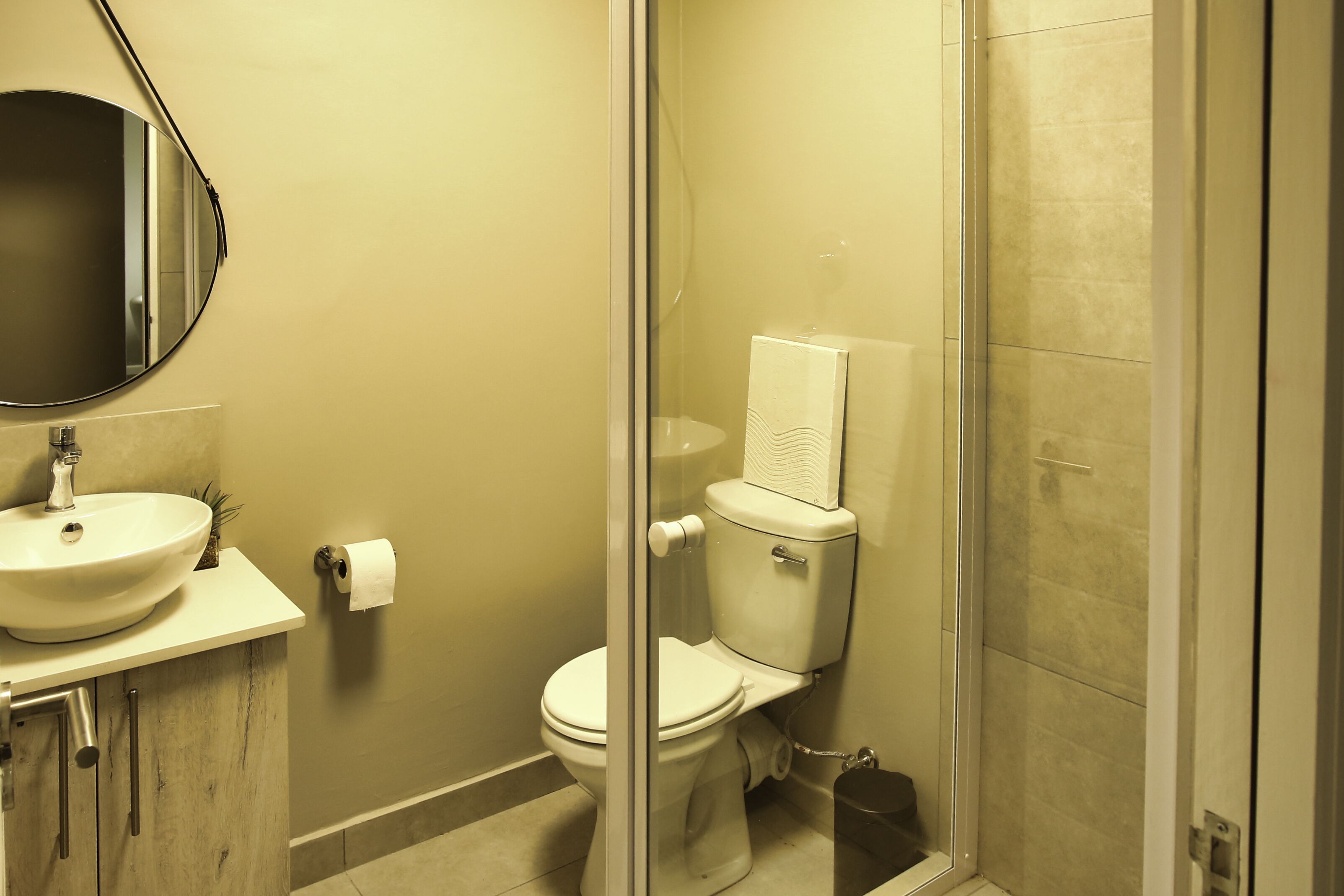 Un bagno con lavandino, WC e cabina doccia in vetro.
