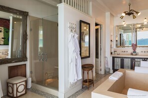 Un baño moderno con ducha de vidrio, un espejo grande y una bañera.