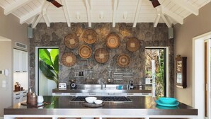 Una cocina moderna con salpicadero de piedra, electrodomésticos de acero inoxidable y cestas tejidas sobre la encimera.