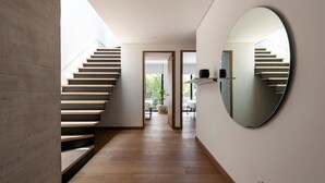 A modern interior with a wooden staircase, a large mirror, and a view into another room. - w* | Inspiring 3BR Duplex with Terrace in Polanco (Ciudad de México)