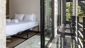 A modern bedroom with a bed, a large window, and a balcony with a metal railing. - w* | Inspiring 3BR Duplex with Terrace in Polanco (Ciudad de México)