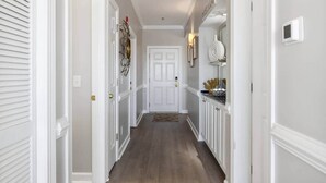 A hallway with white doors, a white ceiling, and a brown floor.