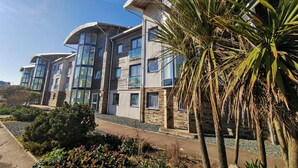 A multi-story building with a modern architectural design, featuring large windows and a mix of stone and wood materials.