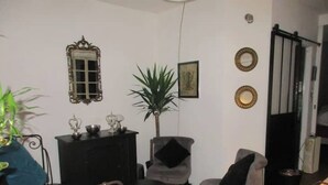 A room with a bed, two armchairs, a small table, a dresser, and a mirror on the wall. - Nice 2 rooms in the center of town, close to the Garonne river (Toulouse)
