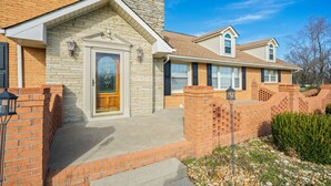A two-story house with a brick facade, a front porch, and a chimney. - Country living at its best, with a beautiful stocked pond to fish in (Springfield)