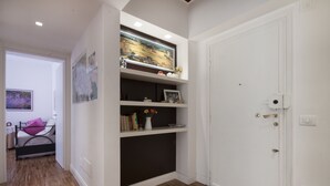 A room with a bed, a shelf with books and decorative items, and a door. - Roma-Incantata, Central, Large Balcony, Next to the main Subway,(Metro A), Park (Roma)