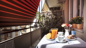 A balcony with a table set for breakfast, including orange juice, coffee, and pastries. - Roma-Incantata, Central, Large Balcony, Next to the main Subway,(Metro A), Park (Roma)
