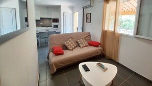 Un salon moderne avec un canapé, une table basse et une télécommande.