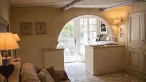 A cozy kitchen with a central island, a dining table, and a sofa. - Mas Dagan, vacation apartments in Saint Remy to dream away on a romantic estate  (Saint-Rémy-De-Provence)