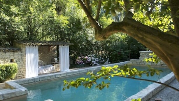 A swimming pool surrounded by stone walls and lush greenery. - Mas Dagan, vacation apartments in Saint Remy to dream away on a romantic estate  (Saint-Rémy-De-Provence)
