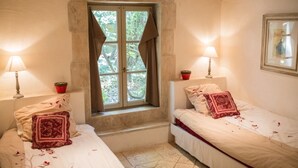 A room with two beds, a window with curtains, and two bedside lamps. - Mas Dagan, vacation apartments in Saint Remy to dream away on a romantic estate  (Saint-Rémy-De-Provence)