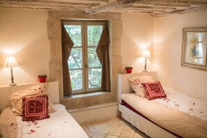 A room with two beds, a window with curtains, and two bedside lamps. - Mas Dagan, vacation apartments in Saint Remy to dream away on a romantic estate  (Saint-Rémy-De-Provence)