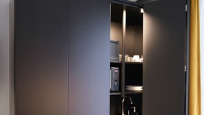 A modern kitchen with dark cabinetry, a built-in microwave, and a sink. - K23 Color Suites (Athens)