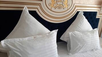 A bed with white pillows and a decorative headboard with a crest.