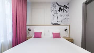 A bedroom with a bed, two bedside tables, a headboard, a pink curtain, and a wall with a graphic.