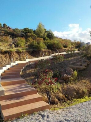 A set of outdoor stone steps leading up a hill with a clear sky above.