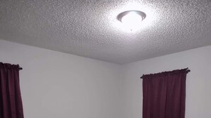 Um quarto com uma cama, uma mesa de cabeceira e um guarda-roupa.