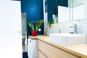 Bathroom features a white sink, chrome faucet, and large mirror.