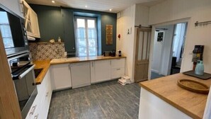 A modern kitchen with white cabinets, a wooden countertop, and a built-in oven. - House in the center, near the beach (Rivedoux-Plage)