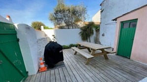 A wooden deck with a picnic table and a covered grill. - House in the center, near the beach (Rivedoux-Plage)