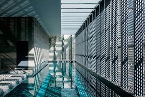 Alberca techada, alberca al aire libre y camastros