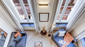 A modern living room with a large window, a round coffee table, and two sofas.