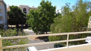 A balcony with a view of a street and trees. - Finfoot Black Apartment, Vilamoura, Algarve (Quarteira)